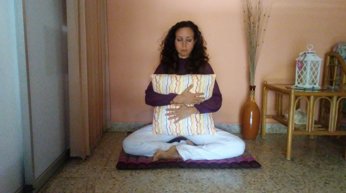 Postura de piernas cruzadas abrazando cojín