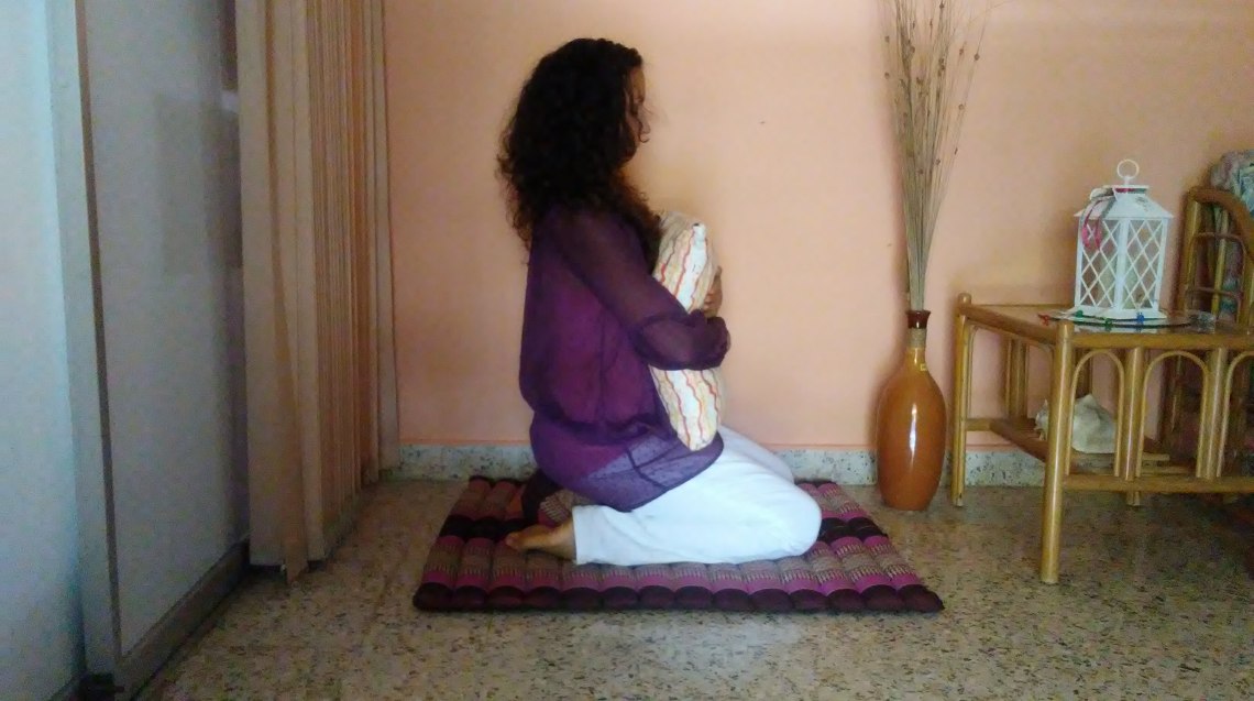 Postura de rodillas abrazando cojín